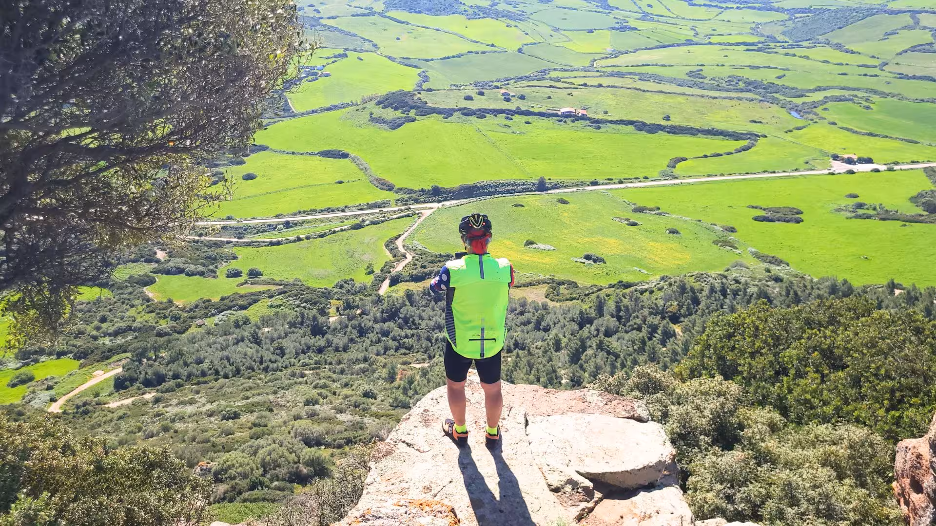 Cyclist overlooking lush green landscapes in Castelsardo, perfect for panoramic ebike adventures.