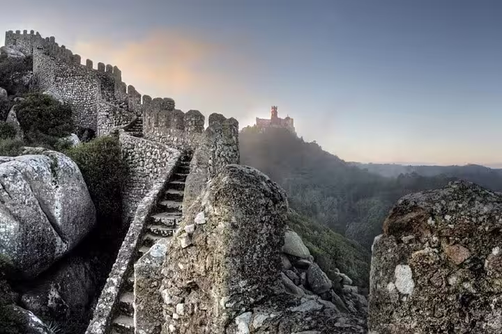 Scenic view of the ancient Castle of the Moors in Sintra with the misty Pena Palace on the horizon.