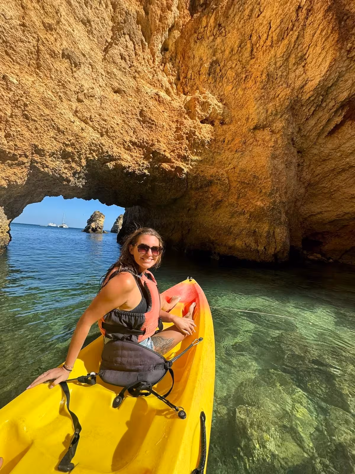 Traveler kayaking through clear waters and golden sea caves on a Benagil and Marinha Beach private catamaran tour in Algarve