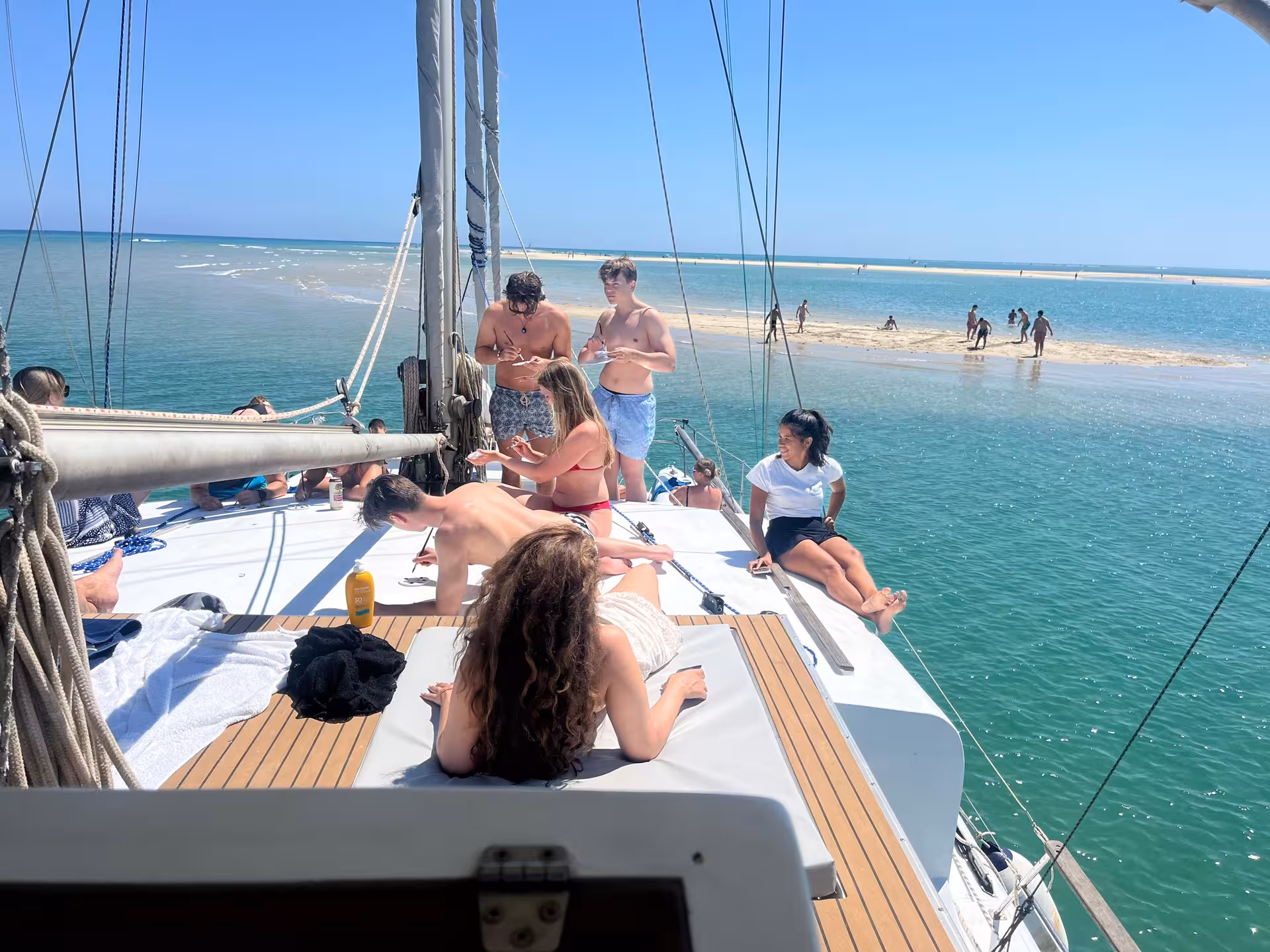 Relaxing on catamaran deck near Blue Lagoon sandbar, a half-day sail with swimming in crystal-clear water