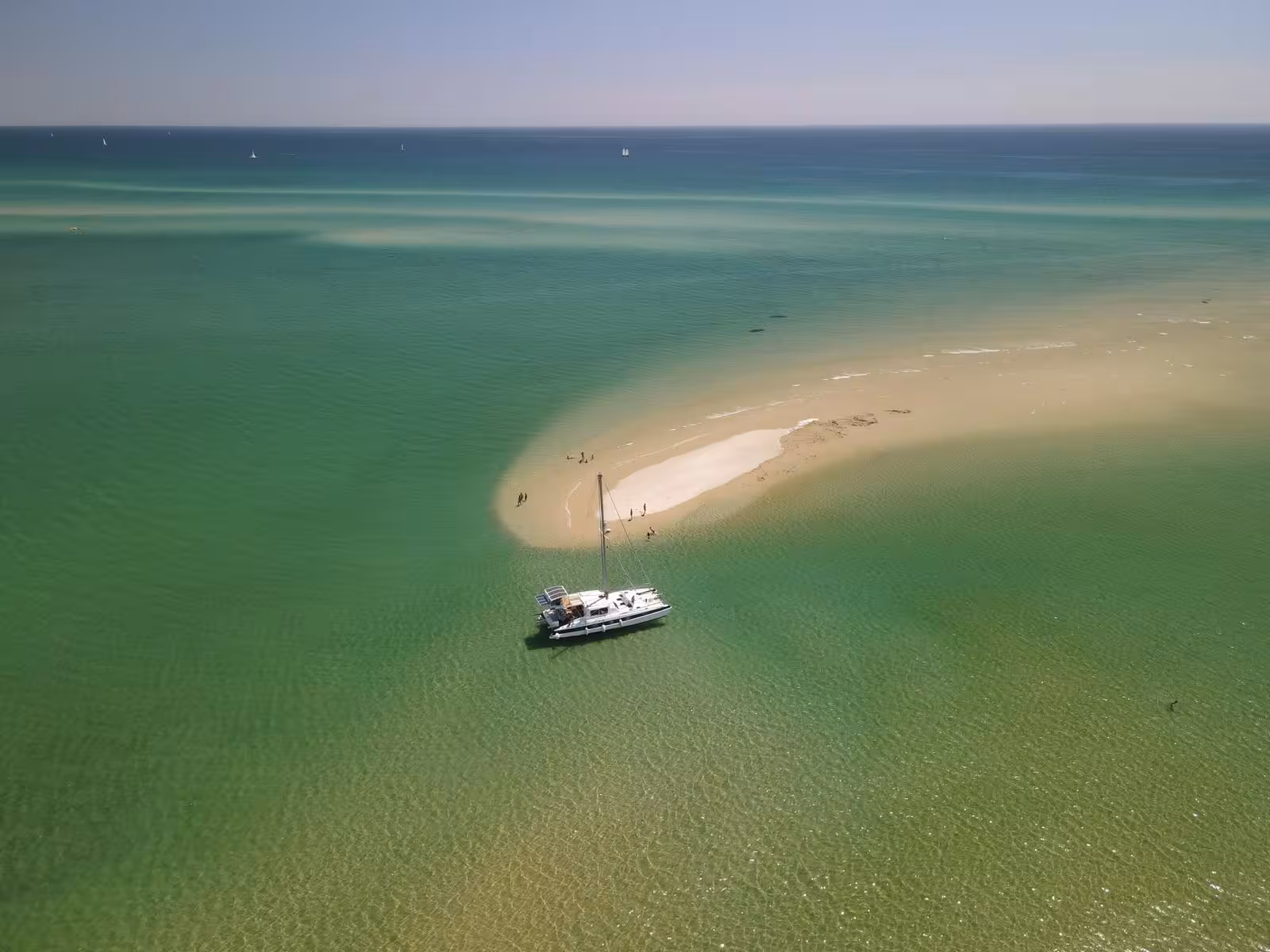Drone shot of catamaran anchored by sandbar in Blue Lagoon, perfect half-day sailing trip for swimming