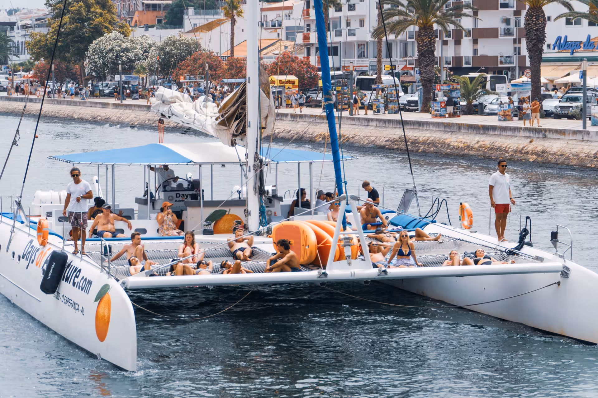 Guests sunbathing on a catamaran in Lagos harbor during a fun boat tour with drinks and live music