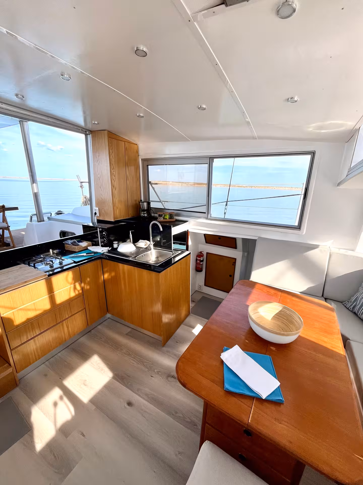 Bright catamaran cabin with kitchenette and dining area, ideal for Malta full-day sail to the Blue Lagoon