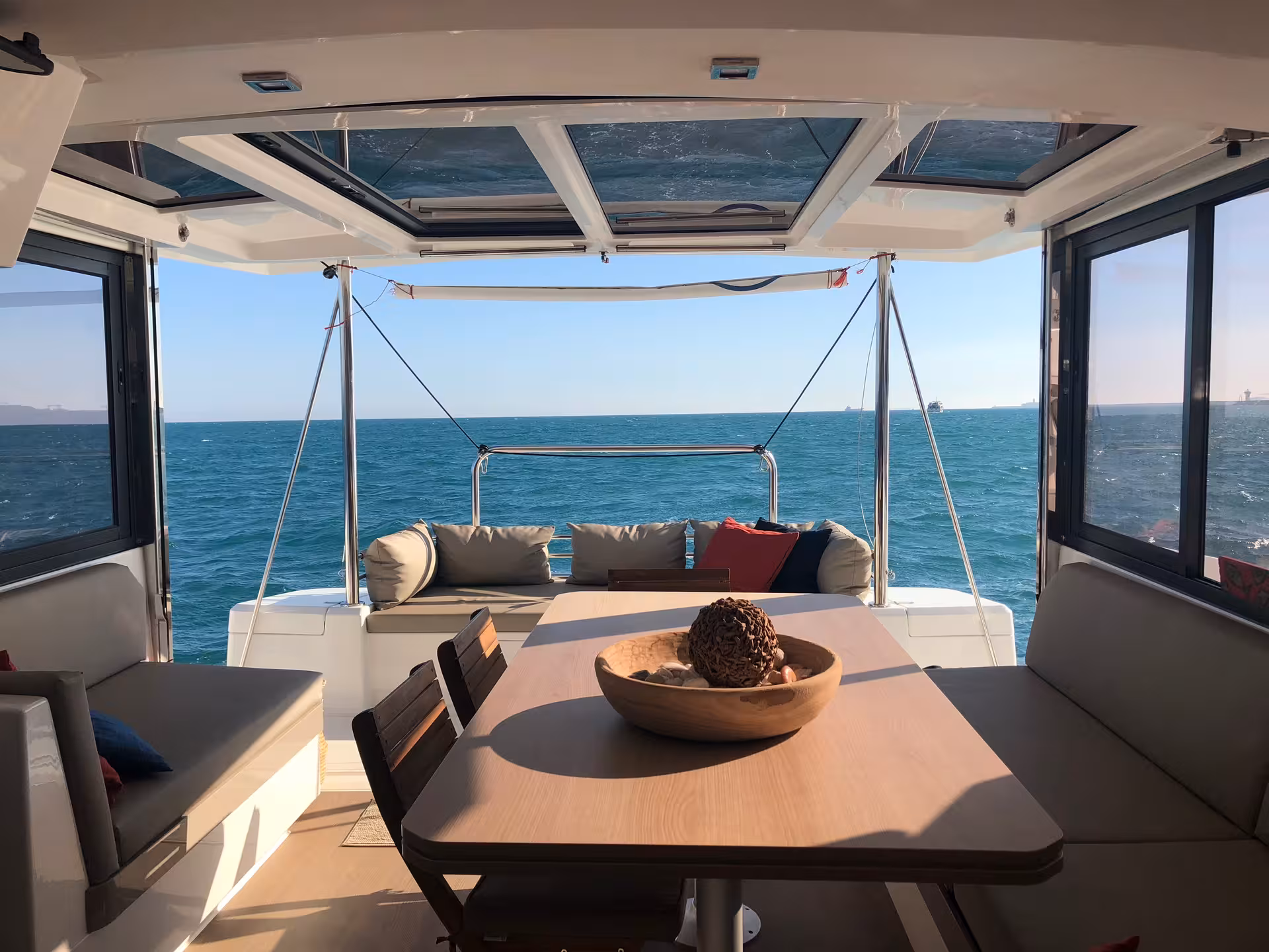 Catamaran cockpit dining area with sea views, perfect spot for a sunset sailing tour with drinks