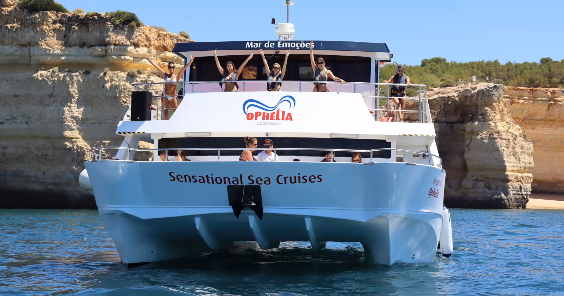 Front view of Catamaran Ophelia cruising near the stunning cliffs of Benagil, perfect for a sea adventure.