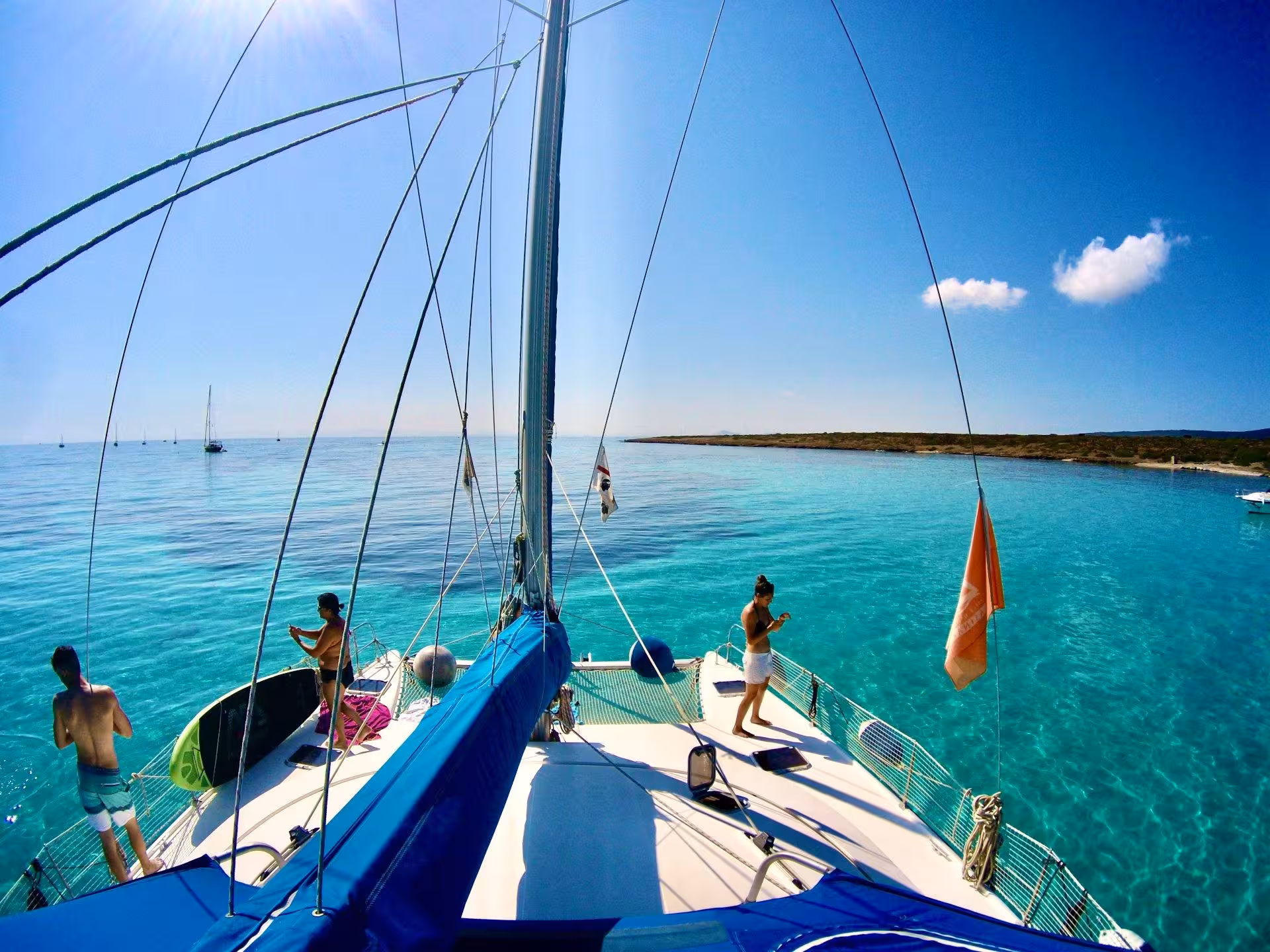 Tourists enjoy the sun on a catamaran deck during a La Maddalena Archipelago tour from Cannigione.