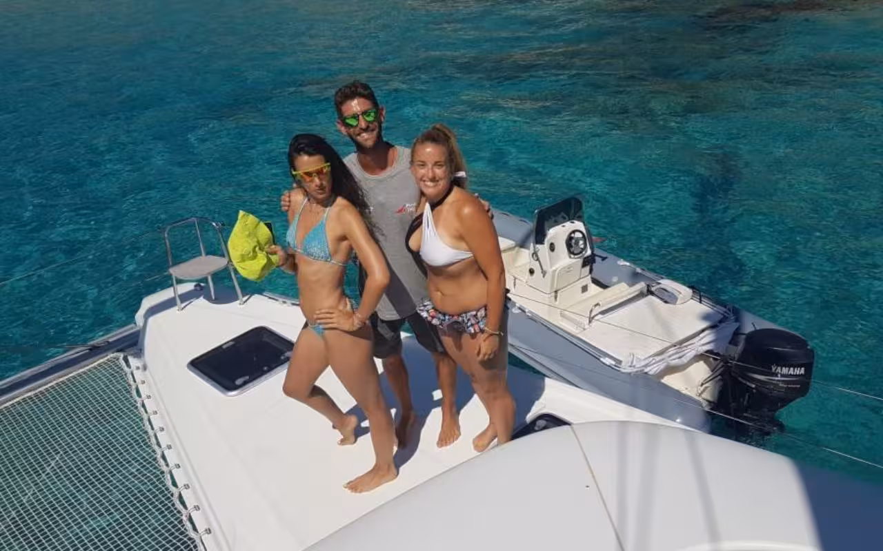 Group enjoying a sunny catamaran tour in the turquoise waters of La Maddalena Archipelago.