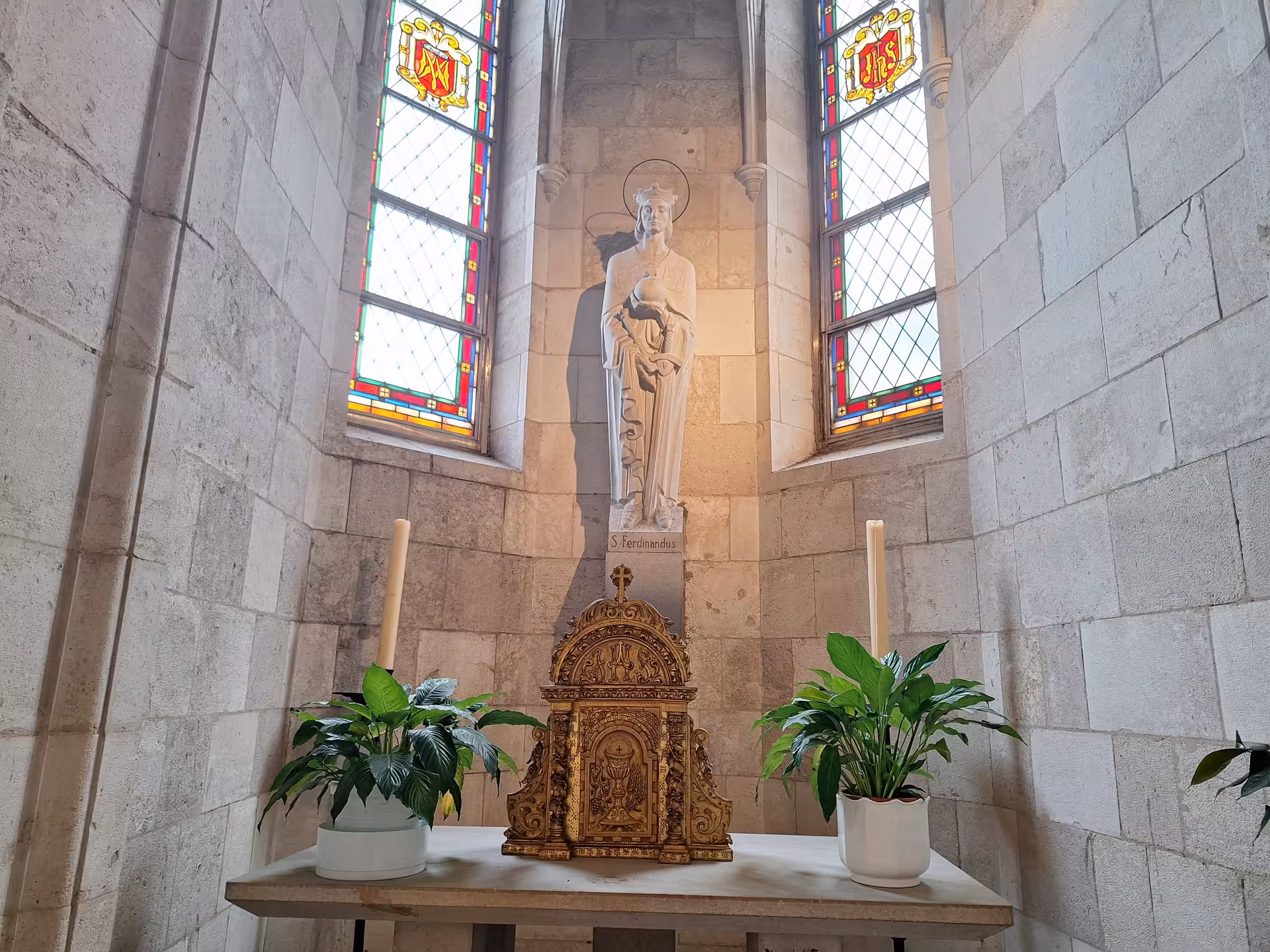 Intricate altar with statue and stained glass at Cathedral of Santander, perfect for a spiritual guided tour.