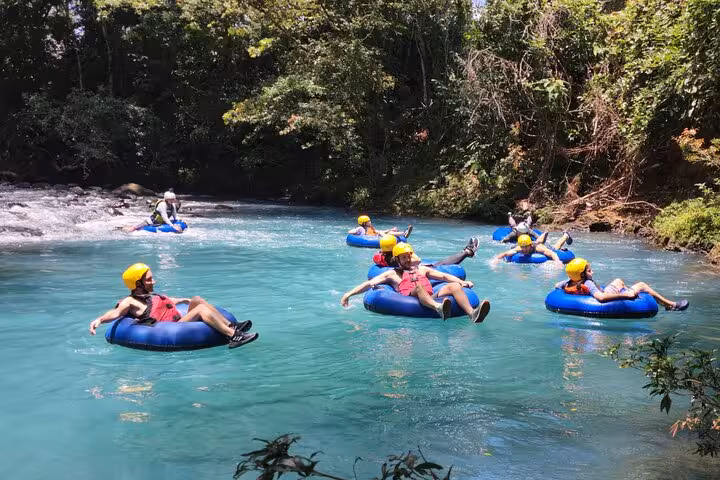 Group enjoying tubing adventure on the pristine Celeste River surrounded by lush rainforest.