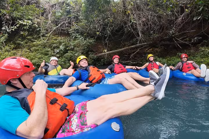 Relaxed group of tubers floating down the Celeste River, enjoying the lush rainforest surroundings.