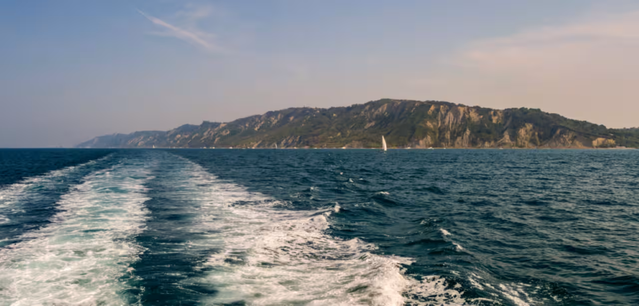 Adriatic Sea wake with coastal cliffs ahead on Cesenatico panoramic tour, scenic boat trip along shore
