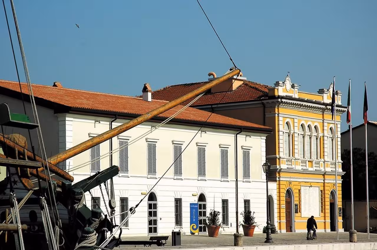 Cesenatico Maritime Museum exterior by the canal, historic building and traditional sailboat rigging in view