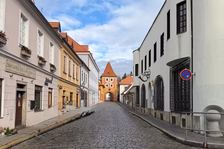 Cobblestone street leading to historic gate in Cesky Krumlov old town on a private day trip from Vienna