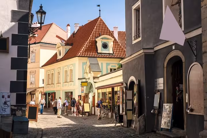 Cobblestone street in Cesky Krumlov Old Town with shops and red roofs on a Vienna day tour