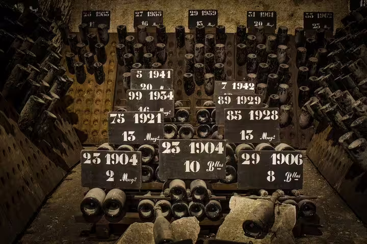 Historic champagne cellar in Reims with vintage bottles, showcasing the rich heritage of French wine production on a Paris day trip.