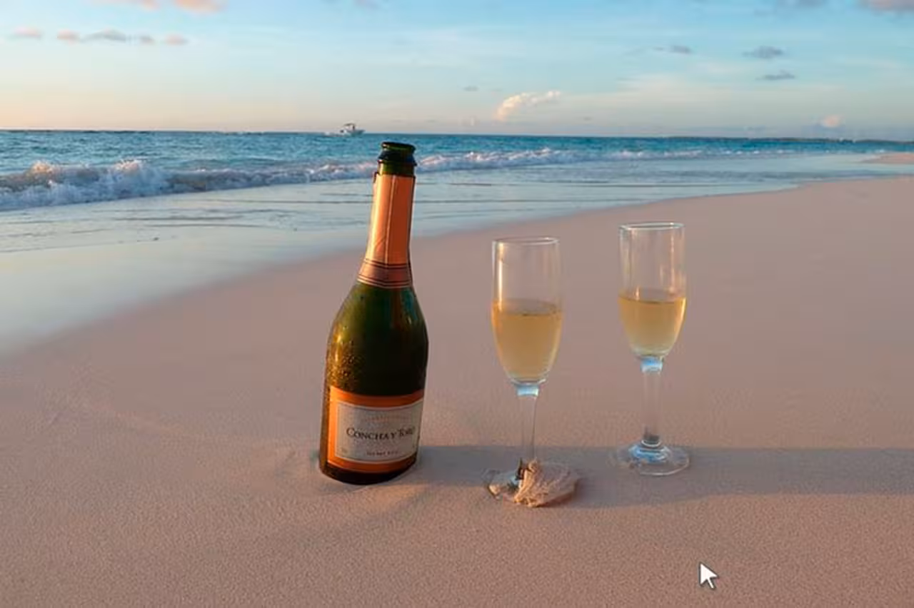 Champagne and two flutes on sandy beach at sunset, romantic private boat tour from Faro Algarve