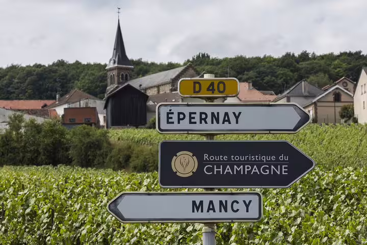Scenic vineyard view with signs pointing to Épernay and Mancy on the Champagne route, ideal for a day trip from Paris.