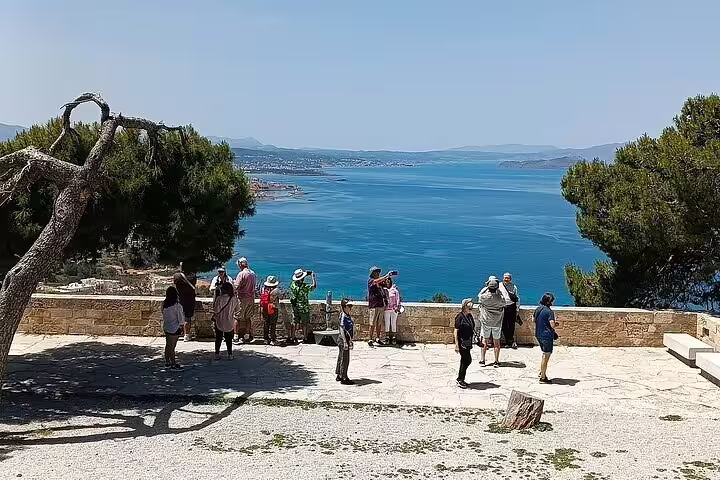Tourists admire the stunning sea view from Agia Triada Monastery, highlighting Chania's breathtaking coastal scenery.