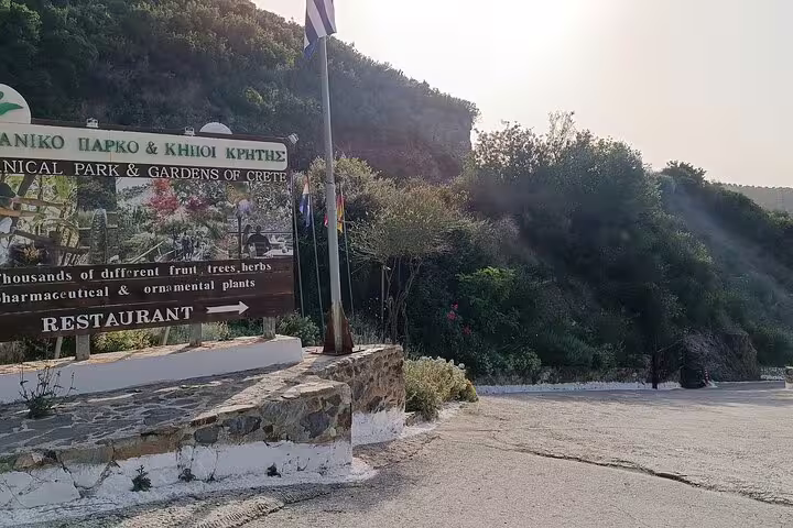 Entrance sign of Chania's Botanical Garden, highlighting diverse plant species and onsite restaurant.