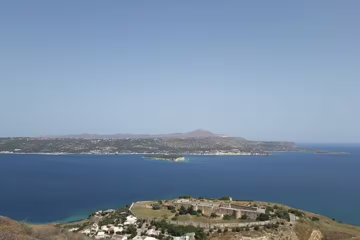Stunning panoramic view of Chania's coastline, highlighting the deep blue sea and distant mountains on a sunny day.