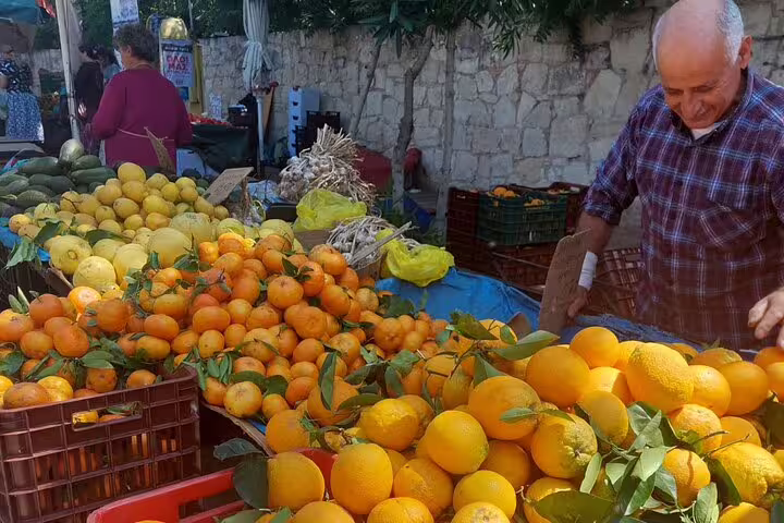 Explore Chania's Farmers Market with vibrant oranges and lemons, freshly picked and displayed by a friendly vendor.
