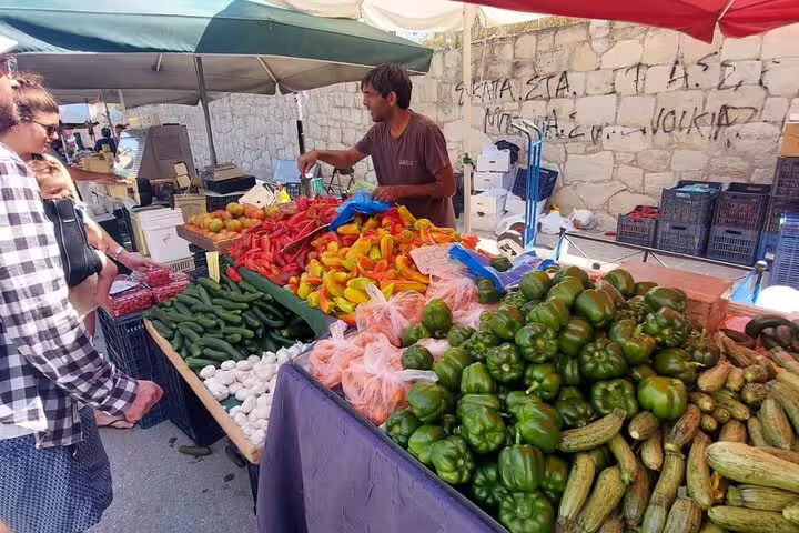 Vibrant display of fresh vegetables at Chania's lively farmers market, featuring peppers, cucumbers, and more.