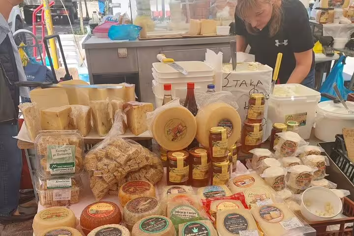 Variety of traditional Greek cheeses and local products on display at Chania's bustling farmers market.