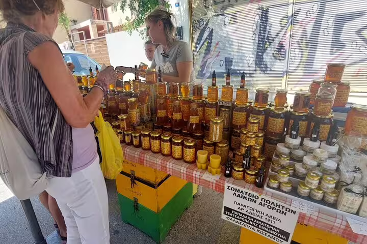 Visitors admire a stall brimming with local honey and artisanal products at Chania's bustling public market.