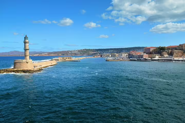 View of the iconic Chania lighthouse and harbor, surrounded by deep blue waters and charming coastal scenery.