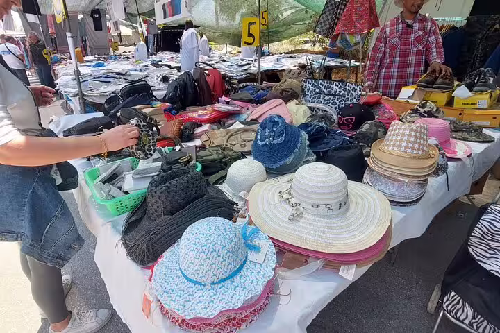 Colorful hat and accessory stall at Chania market featuring a diverse selection of fashion items for sale.