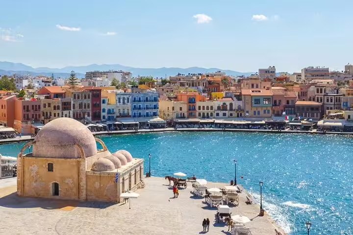 Chania Old Town's scenic harbor view with vibrant waterfront buildings under a clear blue sky, perfect for sightseeing.
