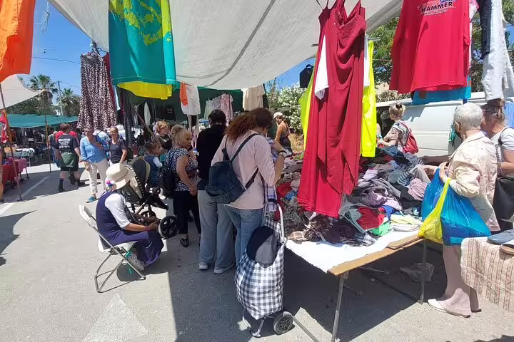 Visitors explore a bustling clothing stall at Chania's vibrant Old Town public and farmers market.