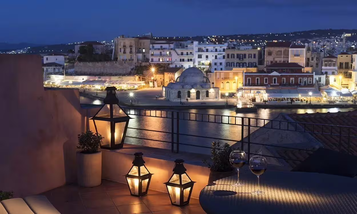 Romantic evening view of Chania Old Town with cozy lantern-lit balcony, ideal for a Crete exploration night setting.