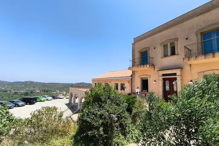 Traditional building of the olive oil mill in Chania Old Town with views of lush greenery and distant hills.