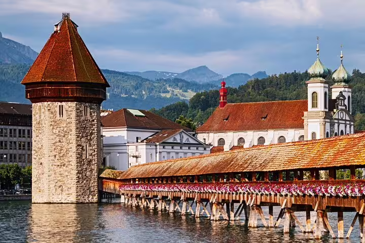 Historic Chapel Bridge and Water Tower in Lucerne, Switzerland, showcasing iconic architecture and vibrant flowers.