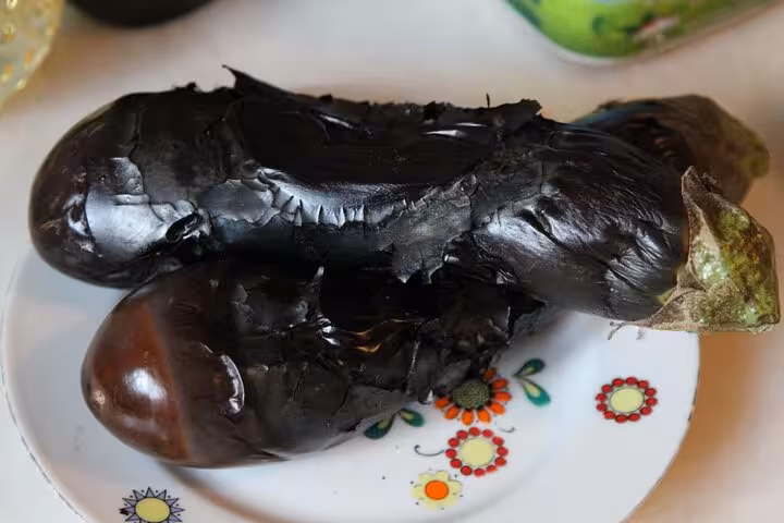 Charred eggplant cooling on a plate for smoky Turkish meze recipe in an Istanbul beginners cooking workshop