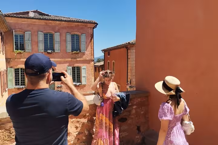 Chauffeured Provence day tour in Roussillon, travelers photographing ochre village streets and houses