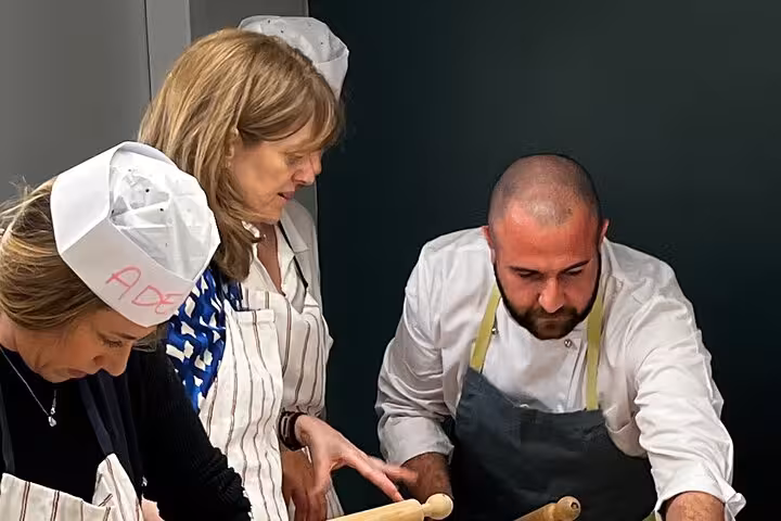 Chef guiding participants in a hands-on fettuccine and ravioli cooking class, perfect for Italian cuisine enthusiasts.
