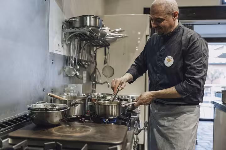 Chef expertly preparing a Tuscan dish at MaMa Florence Cooking Class in Florence kitchen.