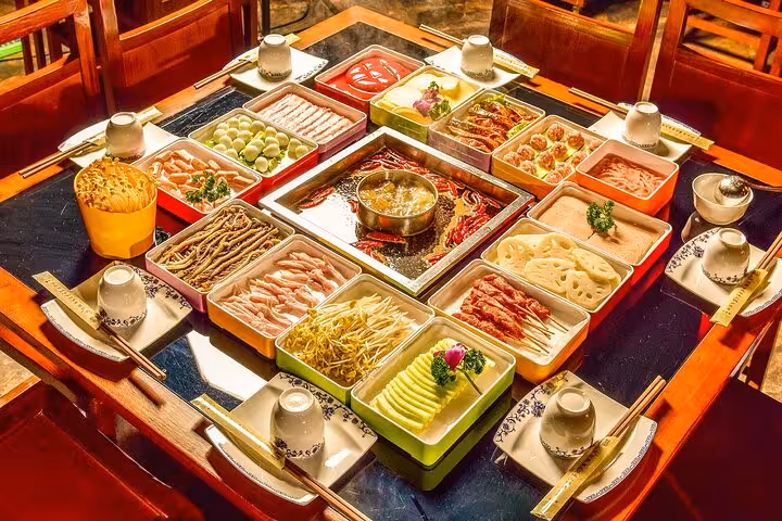 Traditional Sichuan hotpot meal with various ingredients, part of the Chengdu to Leshan tour culinary experience.