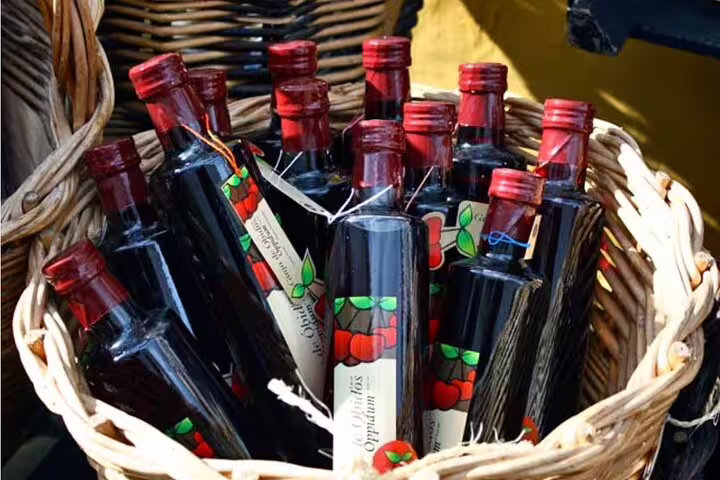 Basket of cherry liqueur bottles, symbolizing local flavors on the Private Full-day Fatima Nazare Obidos Tour from Lisbon.