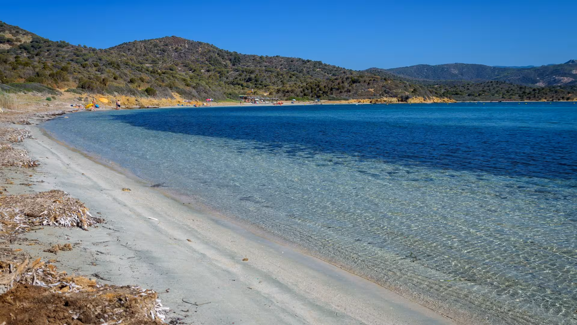 Pristine sandy shores and clear blue waters of Chia, ideal for a 4-hour dinghy tour exploring Sardinia's coastline.