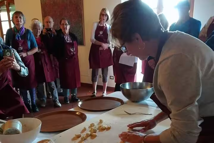 Guests watch an Italian chef hand-make fresh pasta during an authentic Tuscan cooking class in Chianti countryside