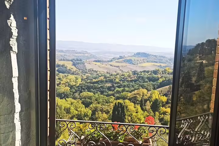 Open window balcony overlooking lush Chianti hills and vineyards, perfect for a romantic Tuscany ramble and wine getaway
