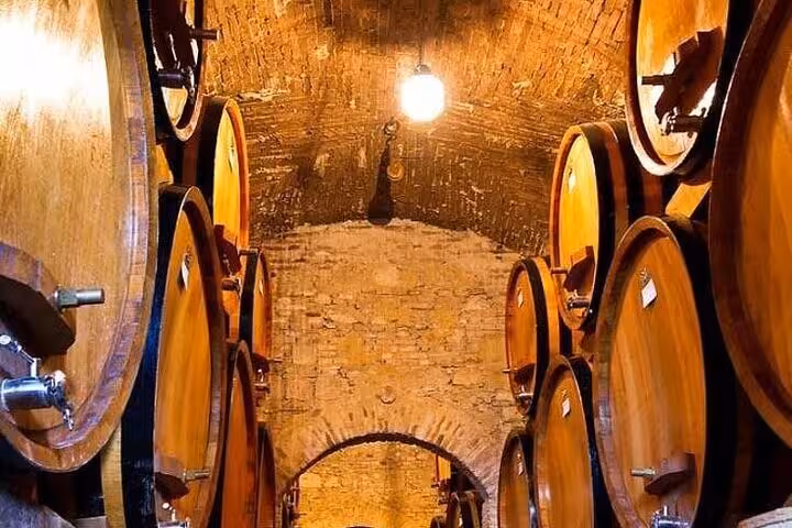 Traditional wine barrels in a Chianti cellar, ideal for a private tour with wine tasting and dinner experience.