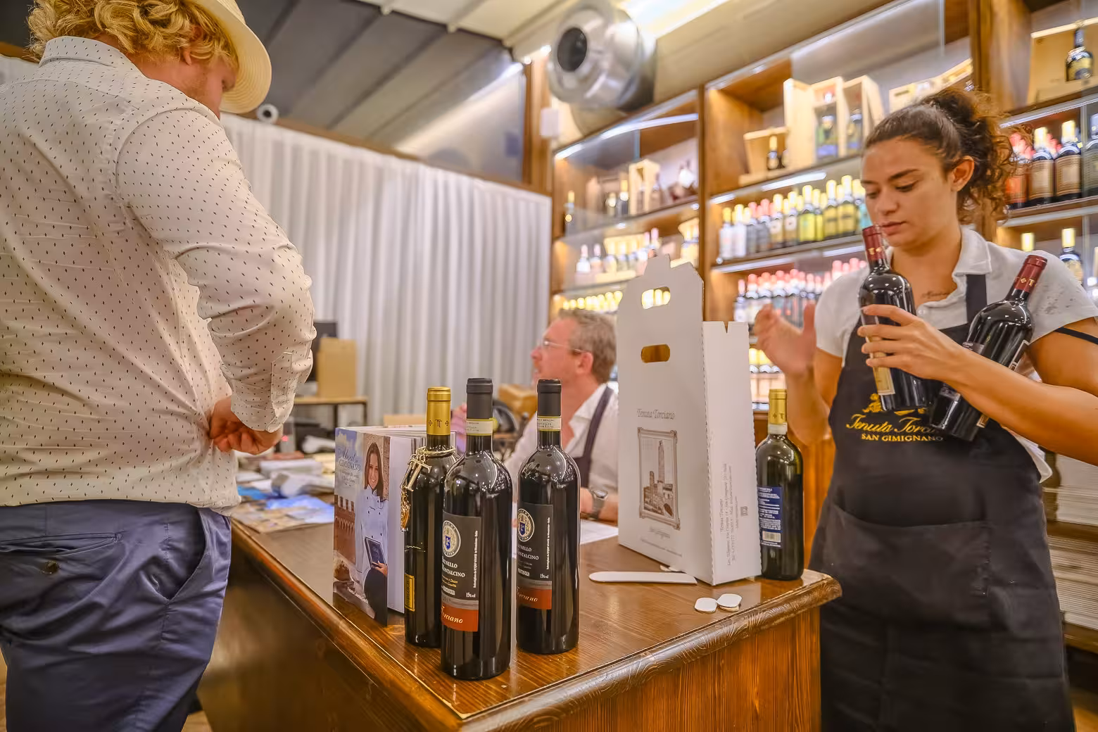 A customer purchases bottles of wine at a Chianti wine store during an afternoon tour from Florence.