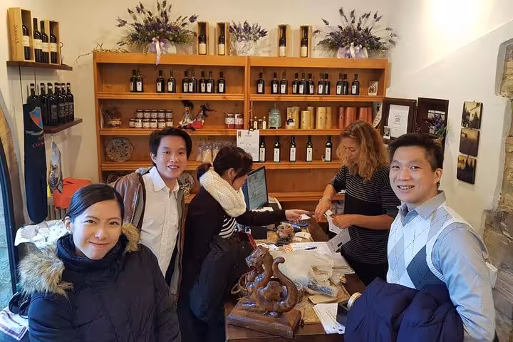 Guests tasting Chianti wines at a Castellina winery shop on Tuscany wine tour from Rome with local products