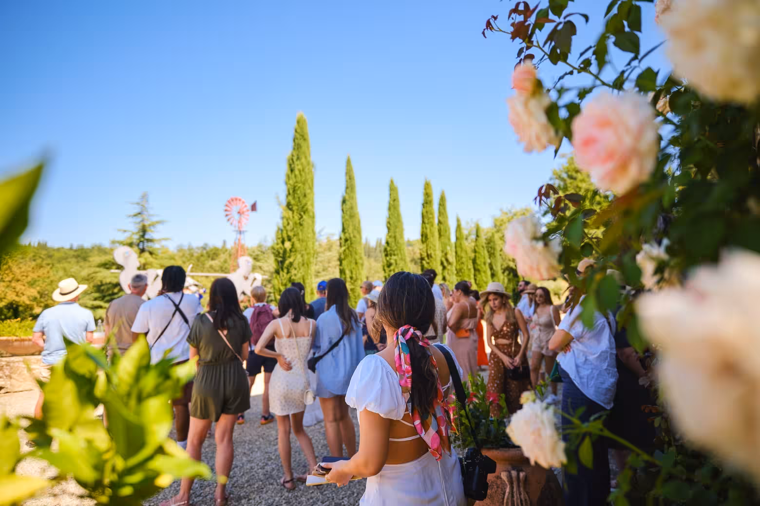 Tourists exploring a picturesque garden in the Chianti wine region on a sunny day tour from Florence.