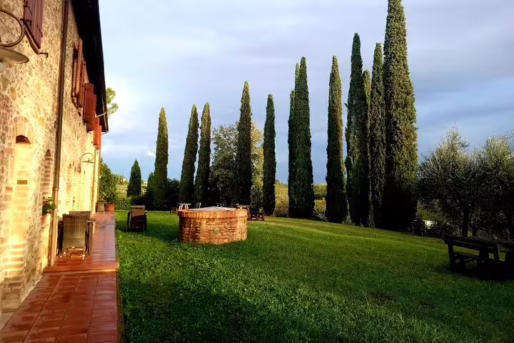 Cypress-lined lawn and rustic stone villa at golden hour on Chianti countryside wine tasting experience