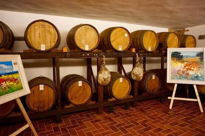 Chianti winery barrel room with aging casks, Tuscany wine tasting and Castellina visit on day trip from Rome